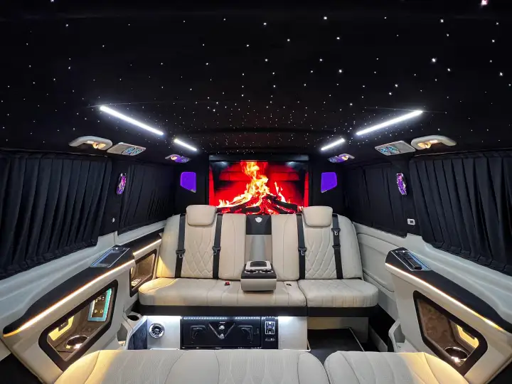 VIP transfer aracında yolcu koltukları, ekran ve yıldız desenli tavan aydınlatması