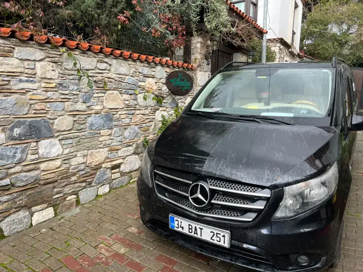 Taş binaların yanında park edilmiş siyah Mercedes Vito